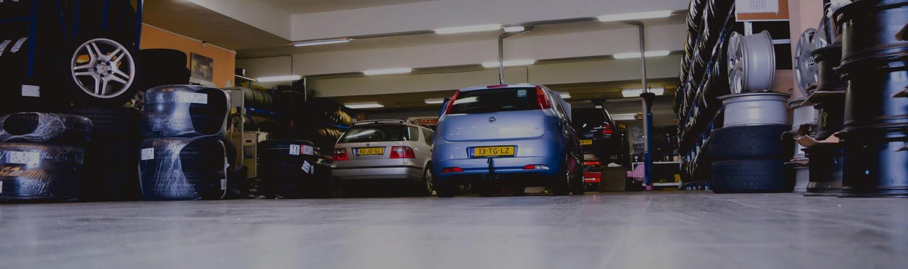 De werkplaats van Autoland Holland met rekken vol banden